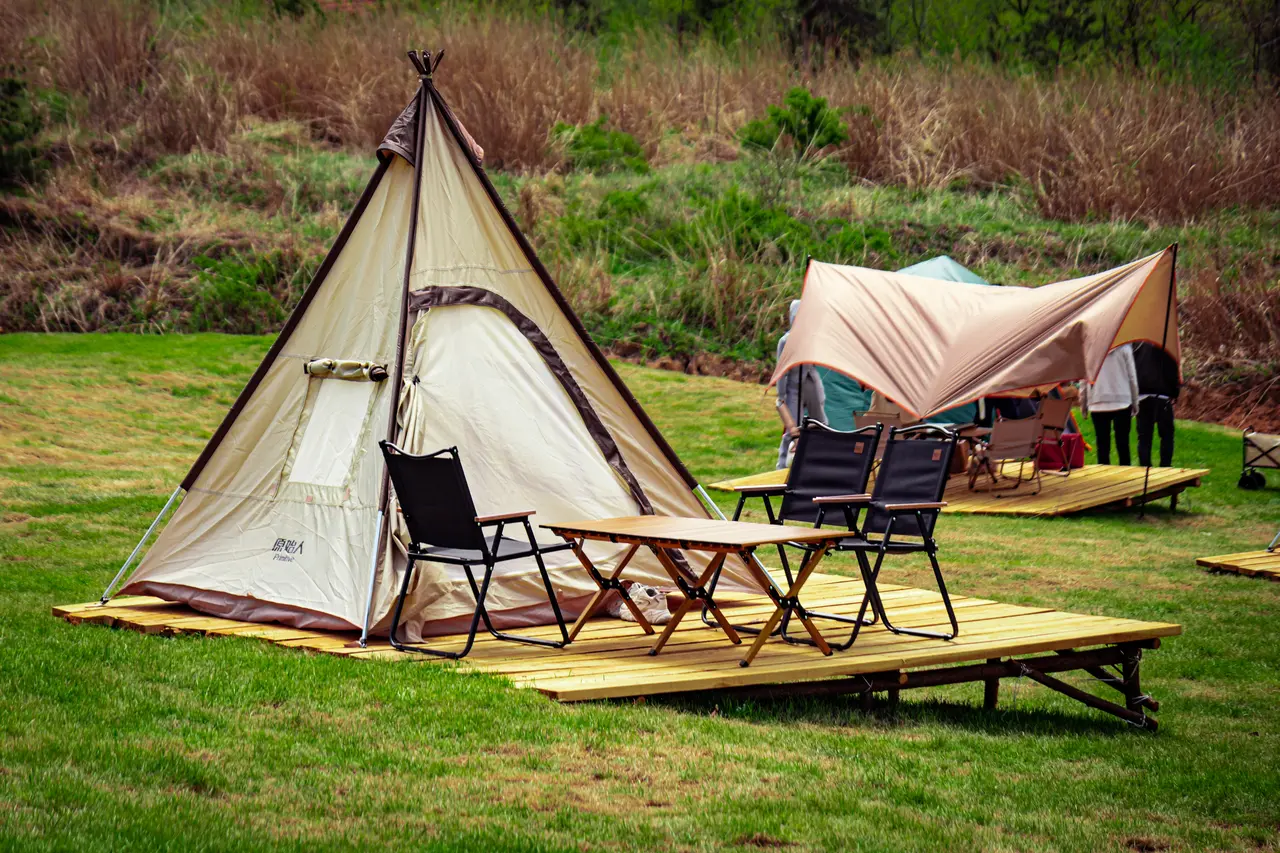 Camping tents on wooden platforms outdoors.